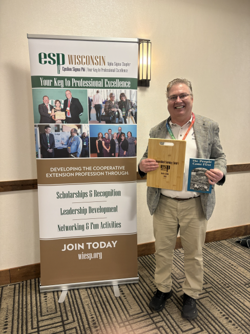 Kevin Jarek standing with an award.