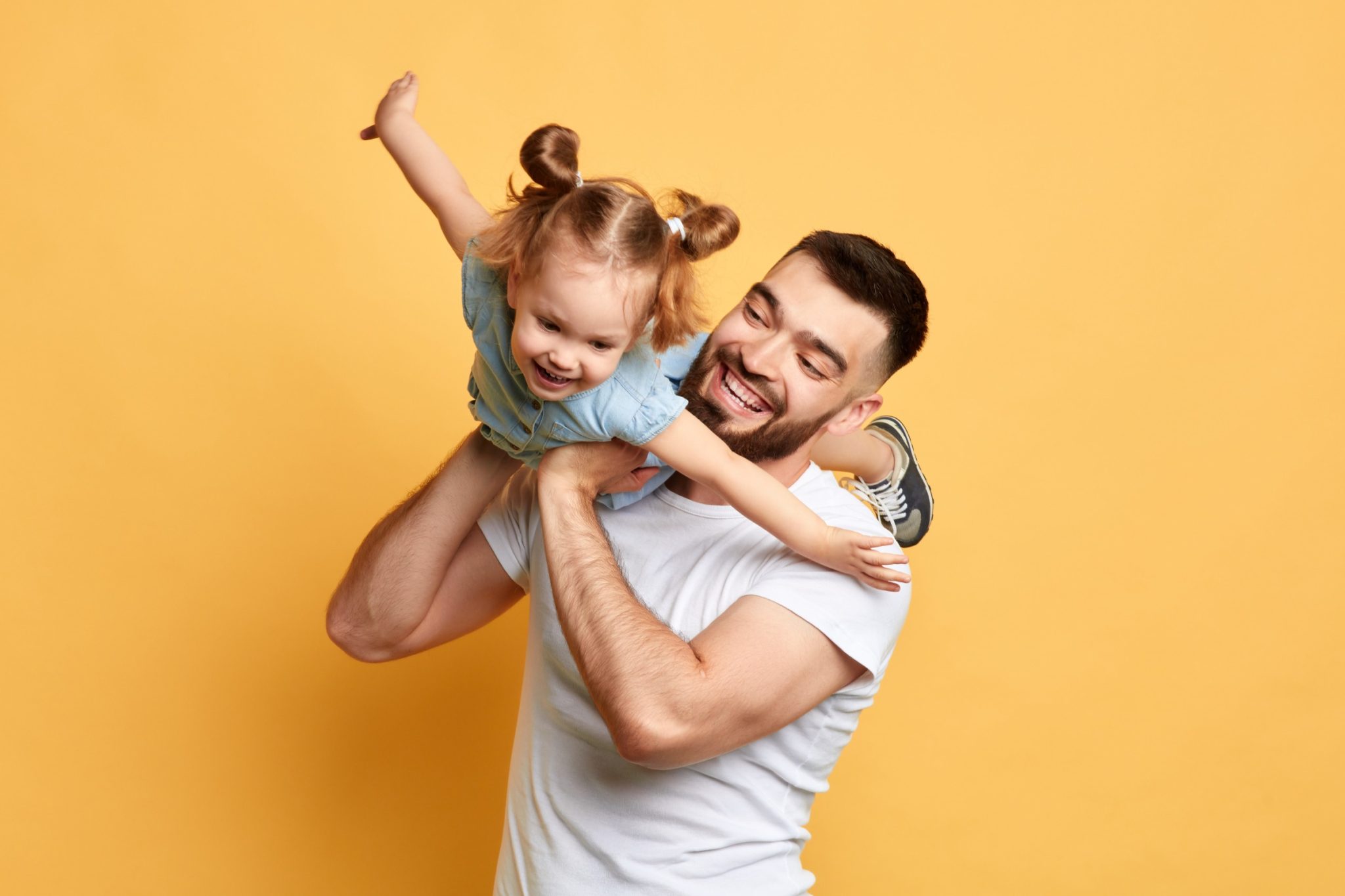 father carrying daughter like an airplane