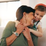 older caregiver enjoying a hug from a young child