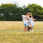 mother embracing young son in an open field