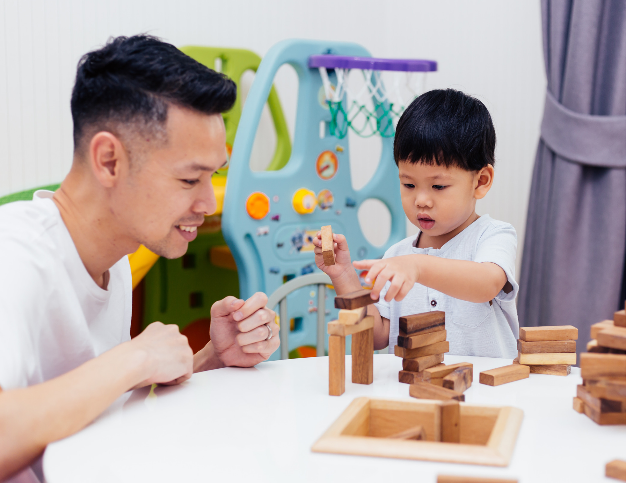 A man and boy playing with block at a table.